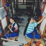 Two women working at carpet looms in Nepal.