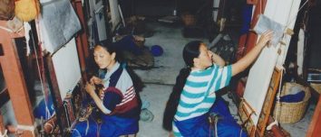 Two women working at carpet looms in Nepal.