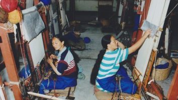 Two women working at carpet looms in Nepal.