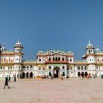 White Janaki Mandir façade and towers beneath a blue sky.