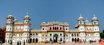 White Janaki Mandir façade and towers beneath a blue sky.