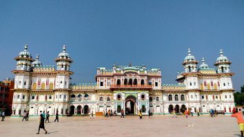 White Janaki Mandir façade and towers beneath a blue sky.