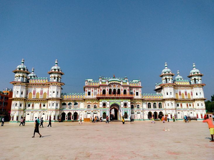 White Janaki Mandir façade and towers beneath a blue sky.