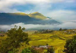 Terraced fields and Khokana settlement beneath misty hills.