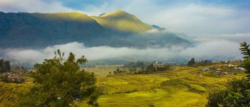 Terraced fields and Khokana settlement beneath misty hills.