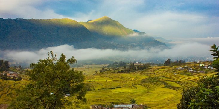 Terraced fields and Khokana settlement beneath misty hills.