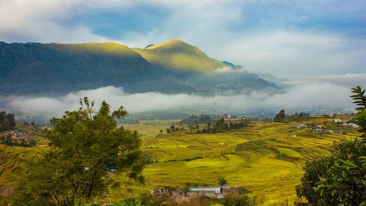 Terraced fields and Khokana settlement beneath misty hills.