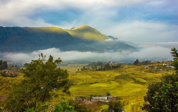 Terraced fields and Khokana settlement beneath misty hills.