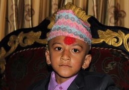 A boy wearing a patterned Dhaka topi.