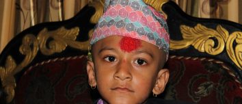 A boy wearing a patterned Dhaka topi.