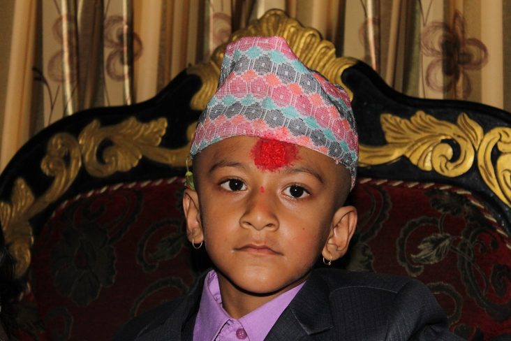 A boy wearing a patterned Dhaka topi.