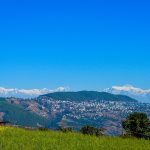 Tansen town on wooded hills with the Himalayan range behind.