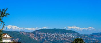 Tansen town on wooded hills with the Himalayan range behind.