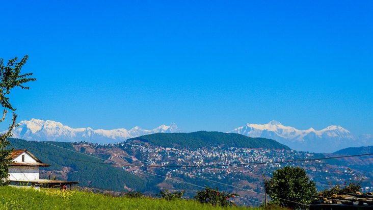 Tansen town on wooded hills with the Himalayan range behind.