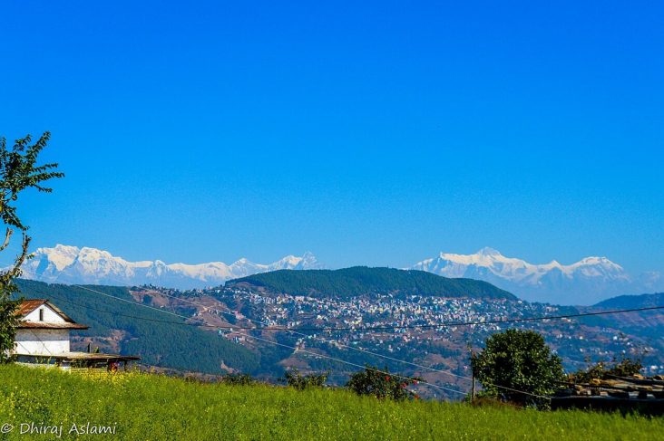 Tansen town on wooded hills with the Himalayan range behind.