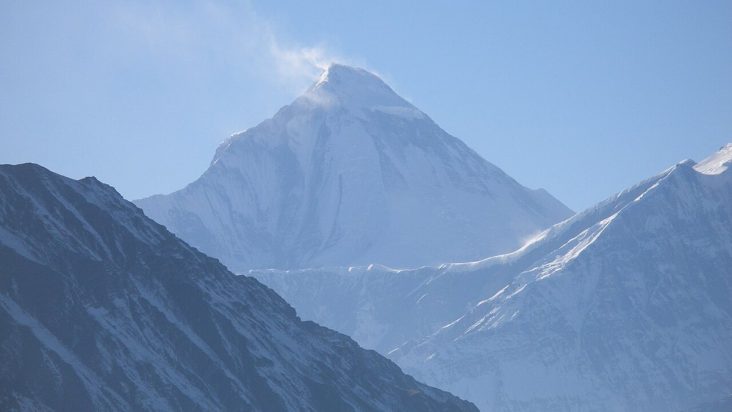 Snow-covered Dhaulagiri above dark Himalayan ridges.